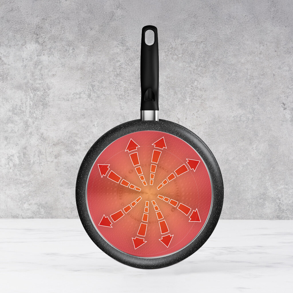 Patelnia z czarną rączką i czerwonym wzorem rozprowadzania ciepła.