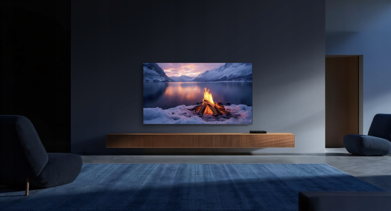 Salon z telewizorem wyświetlającym scenę ogniska w zaśnieżonym krajobrazie.