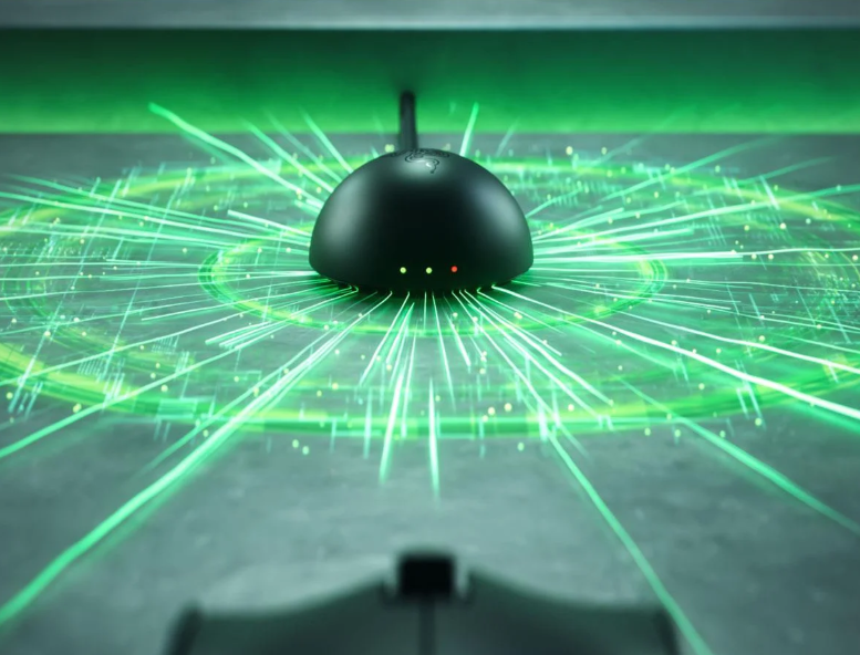 Czarny, okrągły przedmiot na szarej powierzchni z zielonymi promieniami światła.