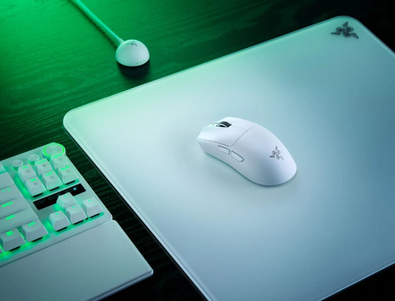 Biała mysz i klawiatura z zielonym podświetleniem na białej macie.