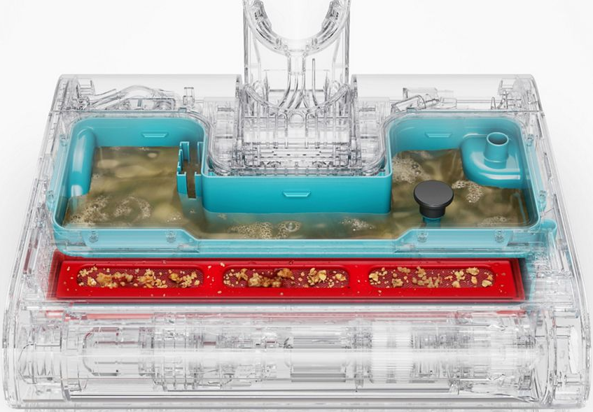 Réservoir transparent d'aspirateur avec insert bleu, rempli d'eau sale et de débris piégés.