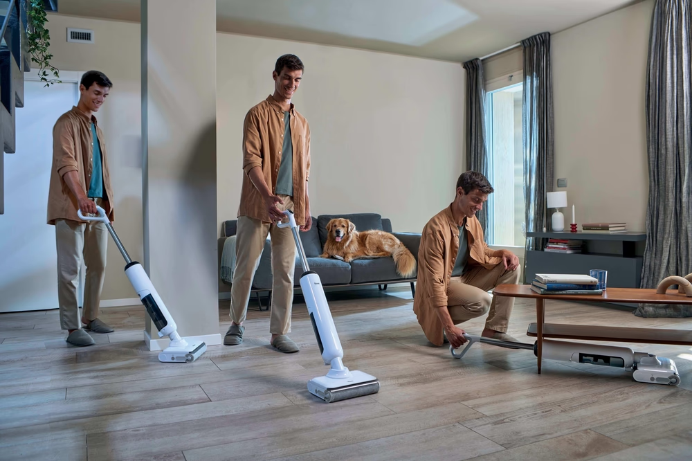Männer saugen und ein Hund auf der Couch in einem modernen Wohnzimmer.