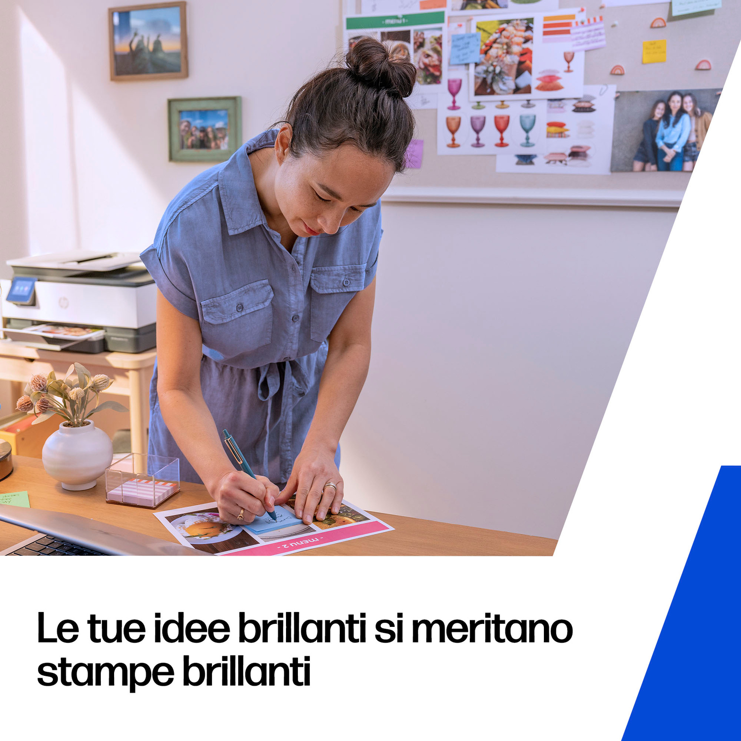 Una donna in abito blu scrive su una stampa, una stampante è vicina.