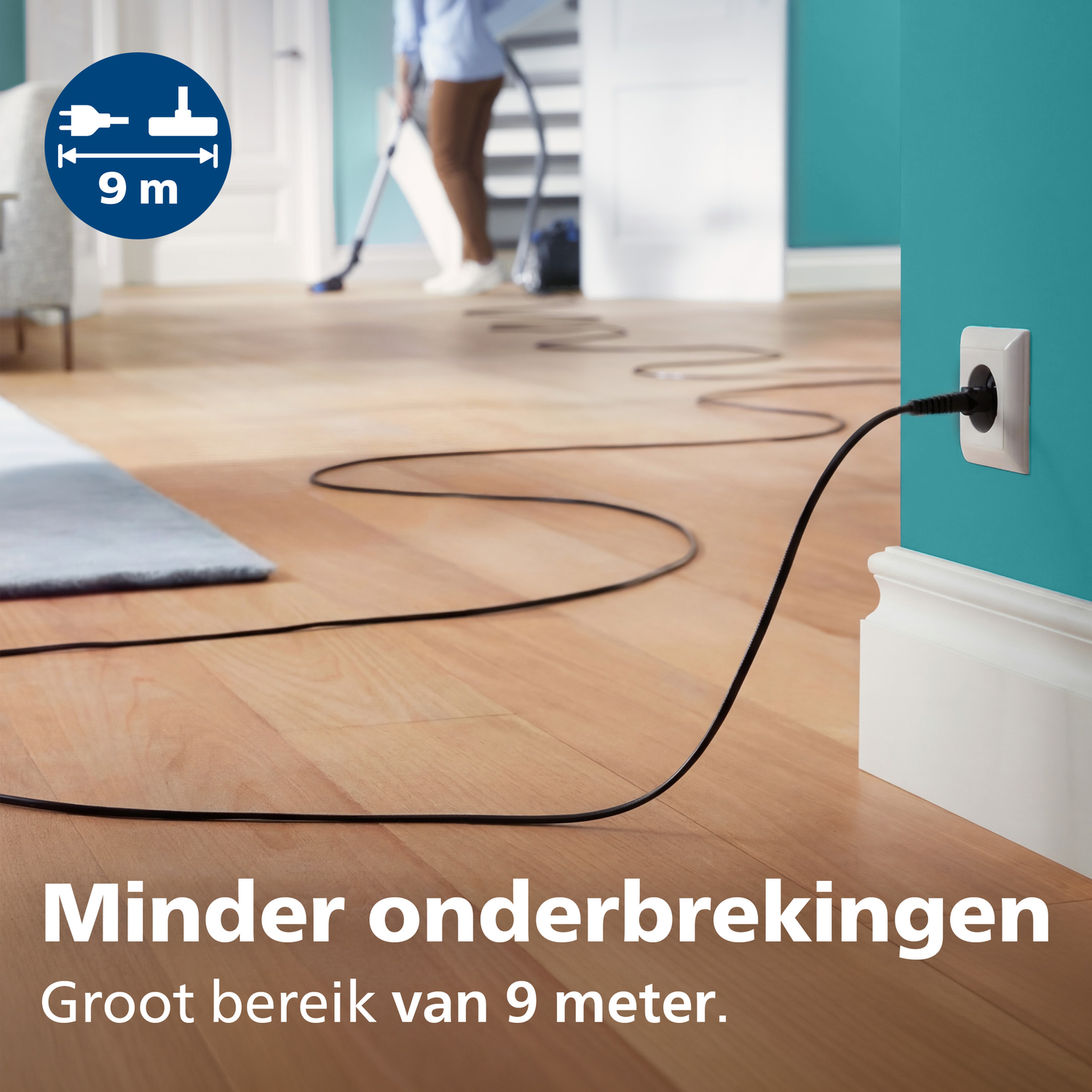 A vacuum cleaner cord plugged into a wall socket stretches across the floor.