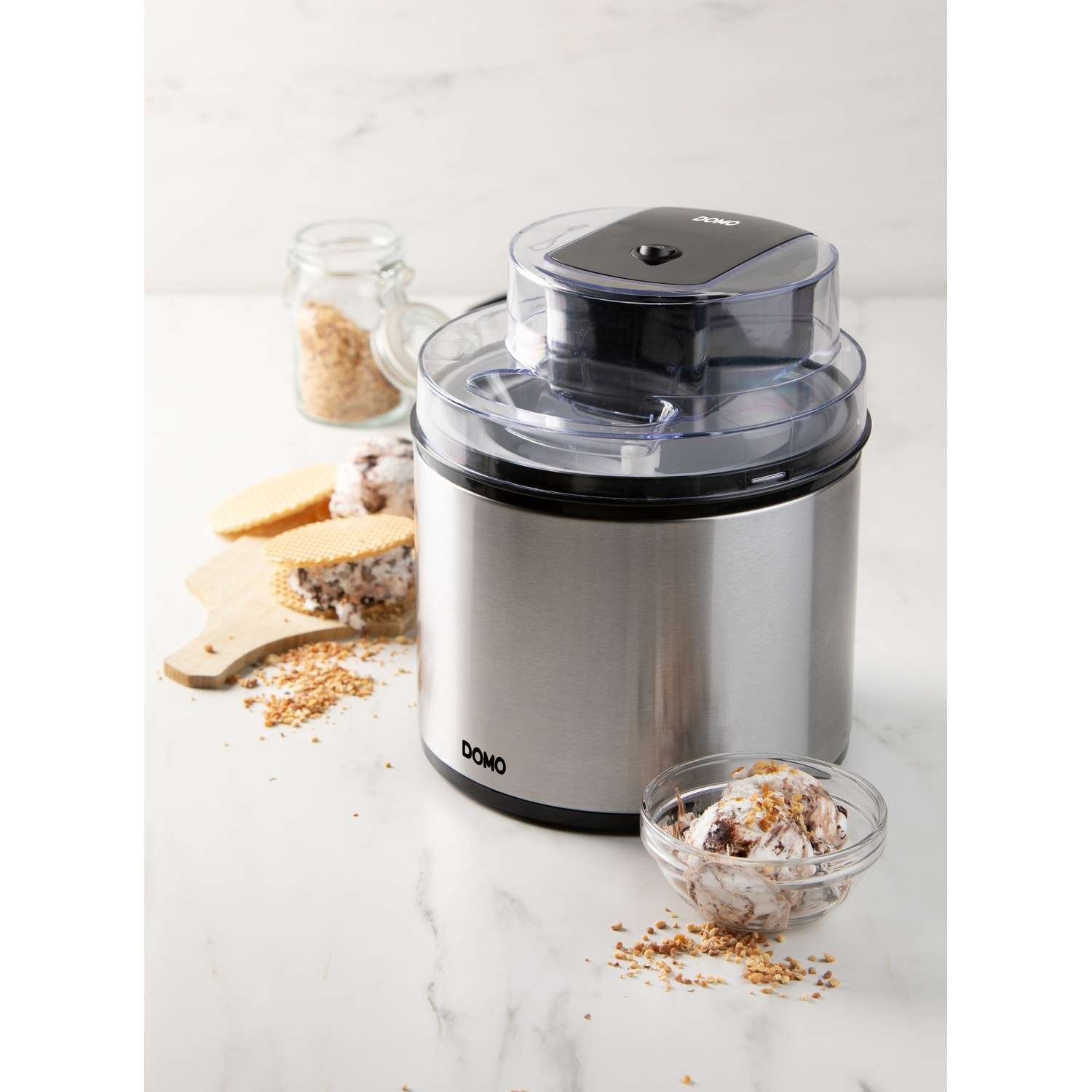RVS ijsmachine met ijs en wafels op marmeren tafel.