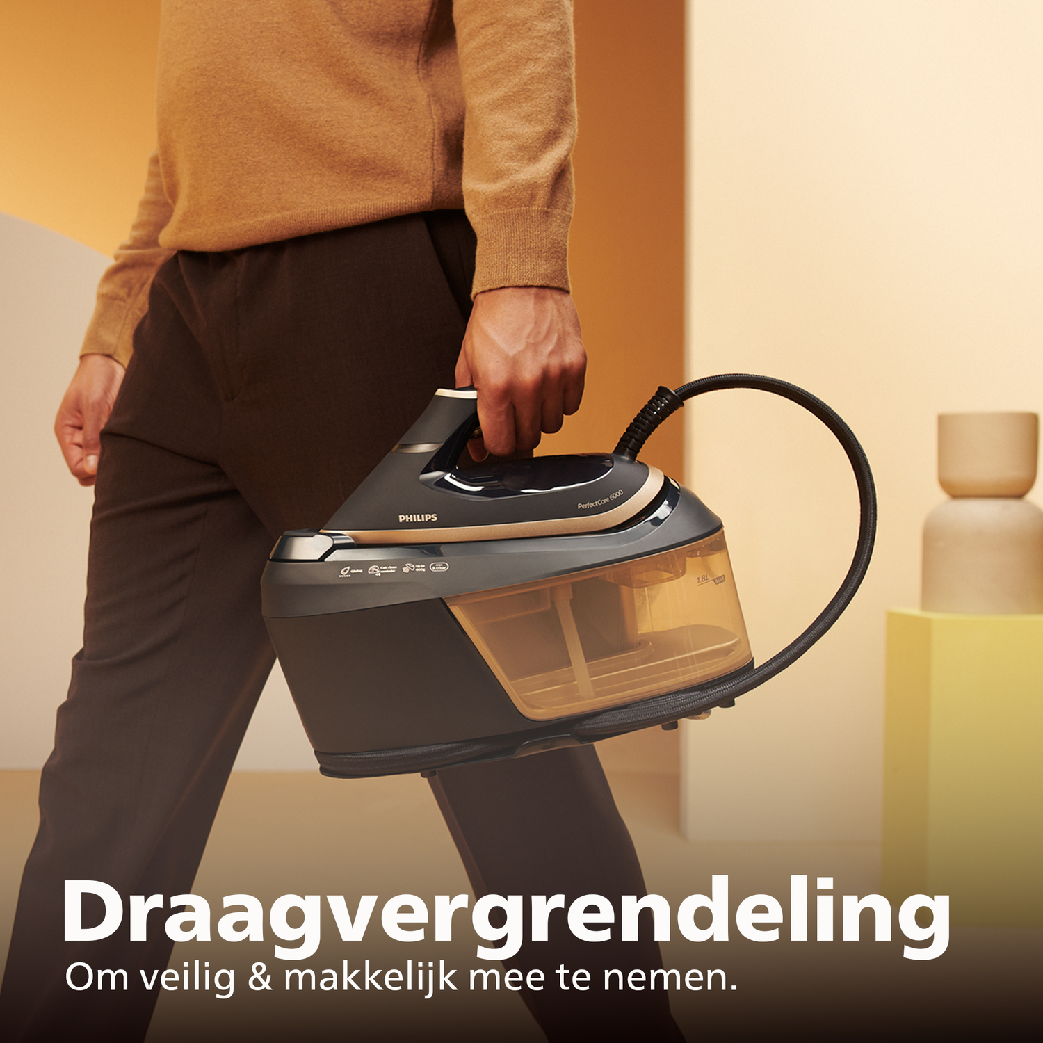 Man houdt Philips stoomstrijkijzer met waterreservoir en slang vast