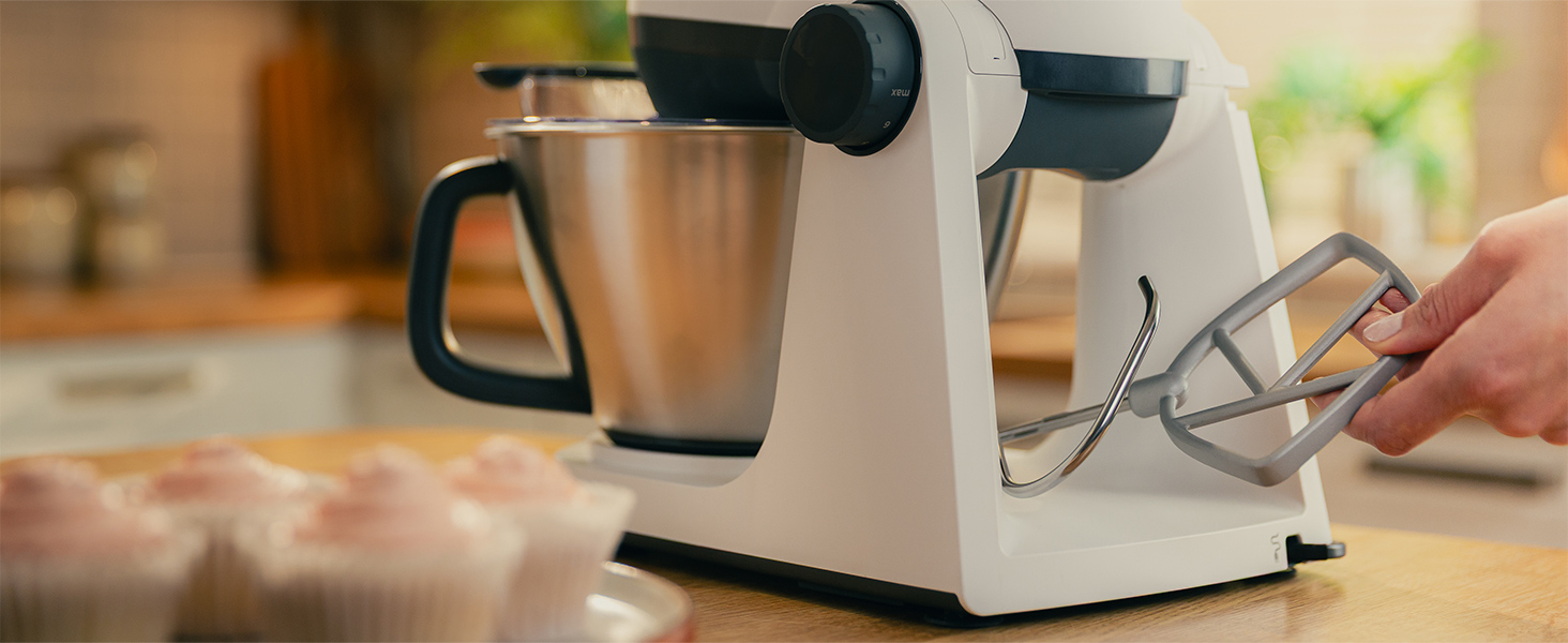 Fehér konyhai robotgép ezüst tálal és rózsaszín cupcake-kel.