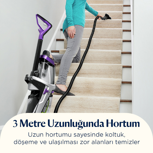Kişi uzun hortumlu elektrikli süpürgeyle merdiven temizliyor.