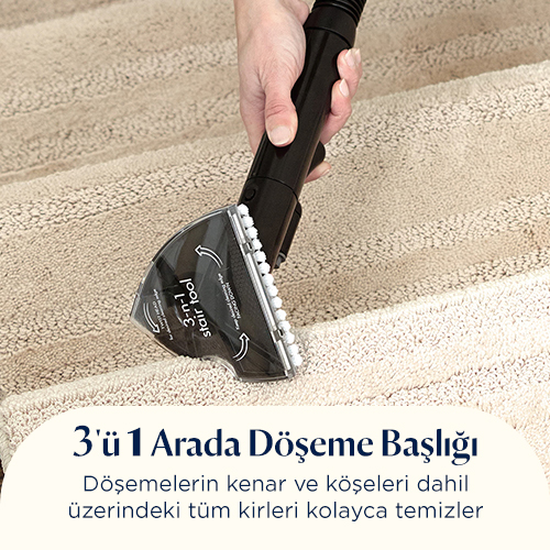 Bir el, bej rengi halı kaplı merdiveni temizleyen bir döşeme başlığı tutuyor.