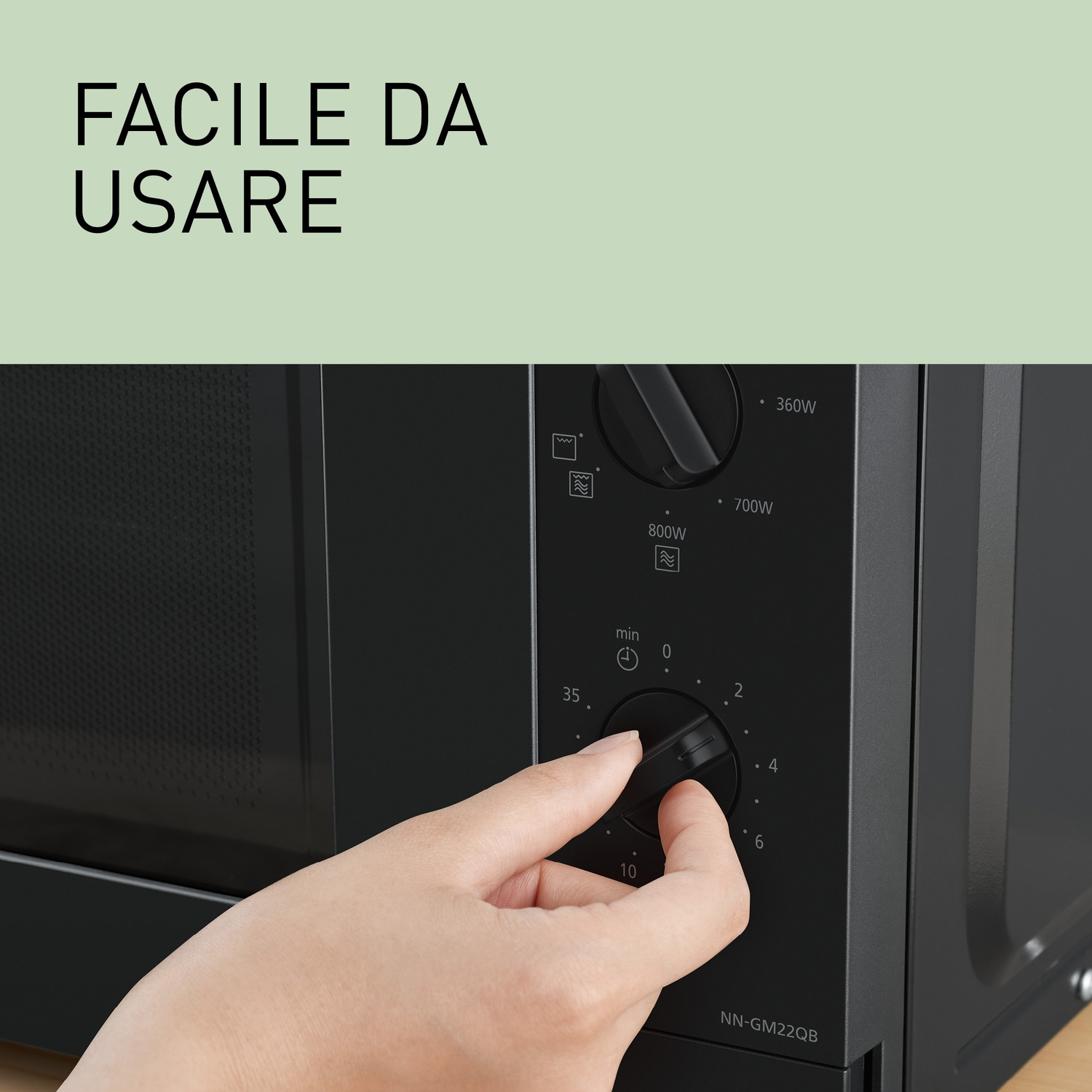 Una mano gira una manopola su un forno a microonde nero con testo "FACILE DA USARE".