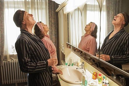Zwei Frauen in Nachtwäsche blicken in einem Badezimmer nach oben.