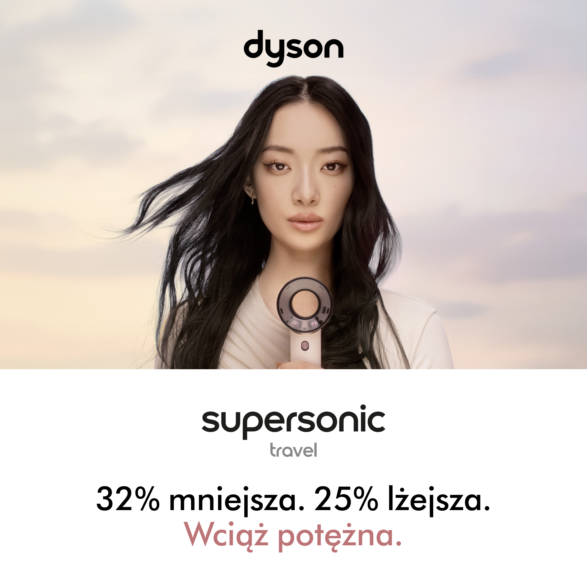 Kobieta z ciemnymi włosami trzyma suszarkę Dyson Supersonic.