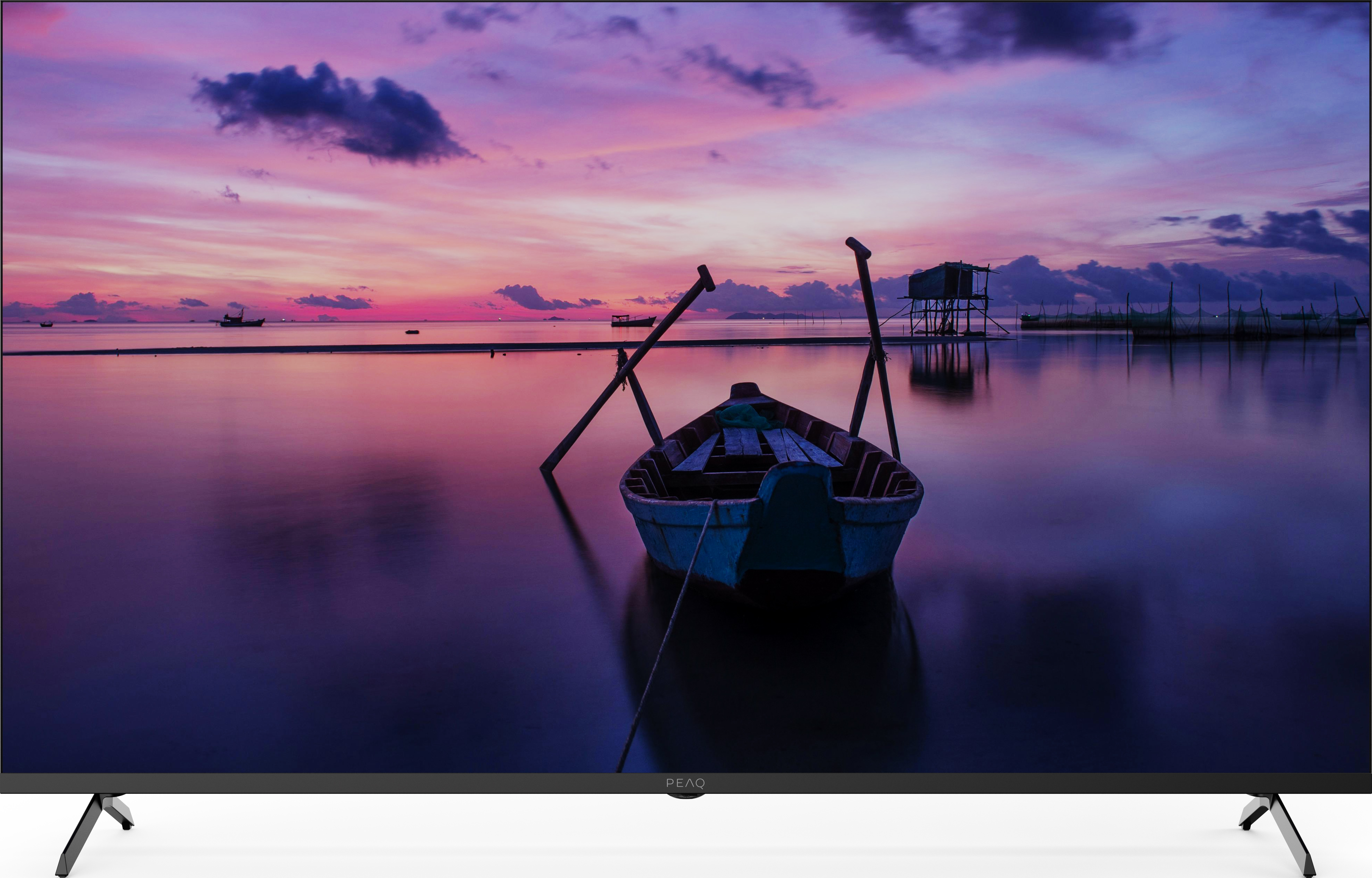 Un bateau bleu sur une eau calme, sous un ciel rose et violet.