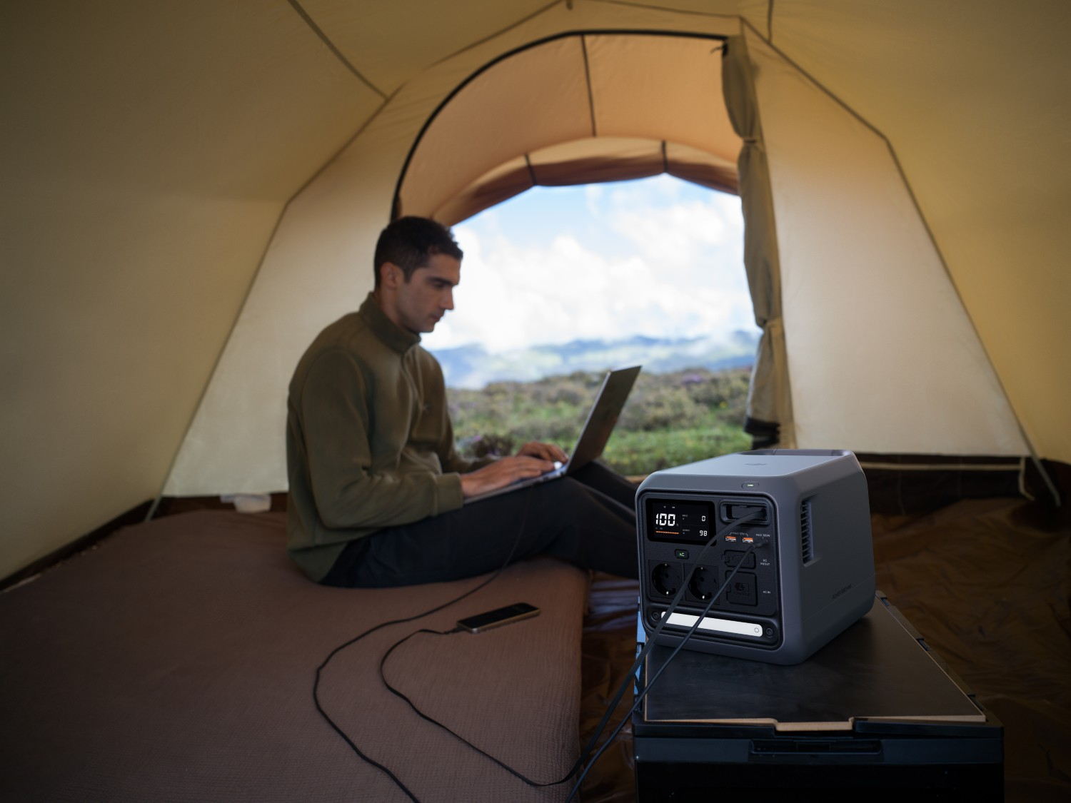 Mężczyzna pracuje na laptopie w namiocie z generatorem.