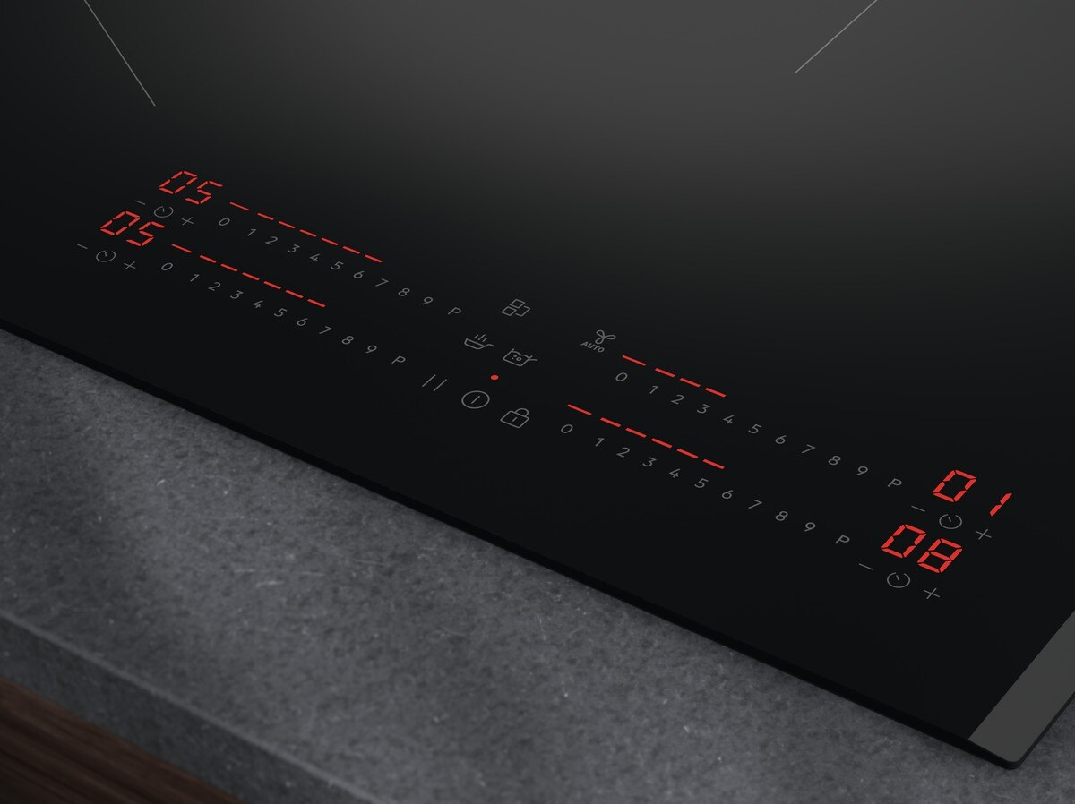 Superficie moderna de placa de inducción negra con pantallas digitales rojas.
