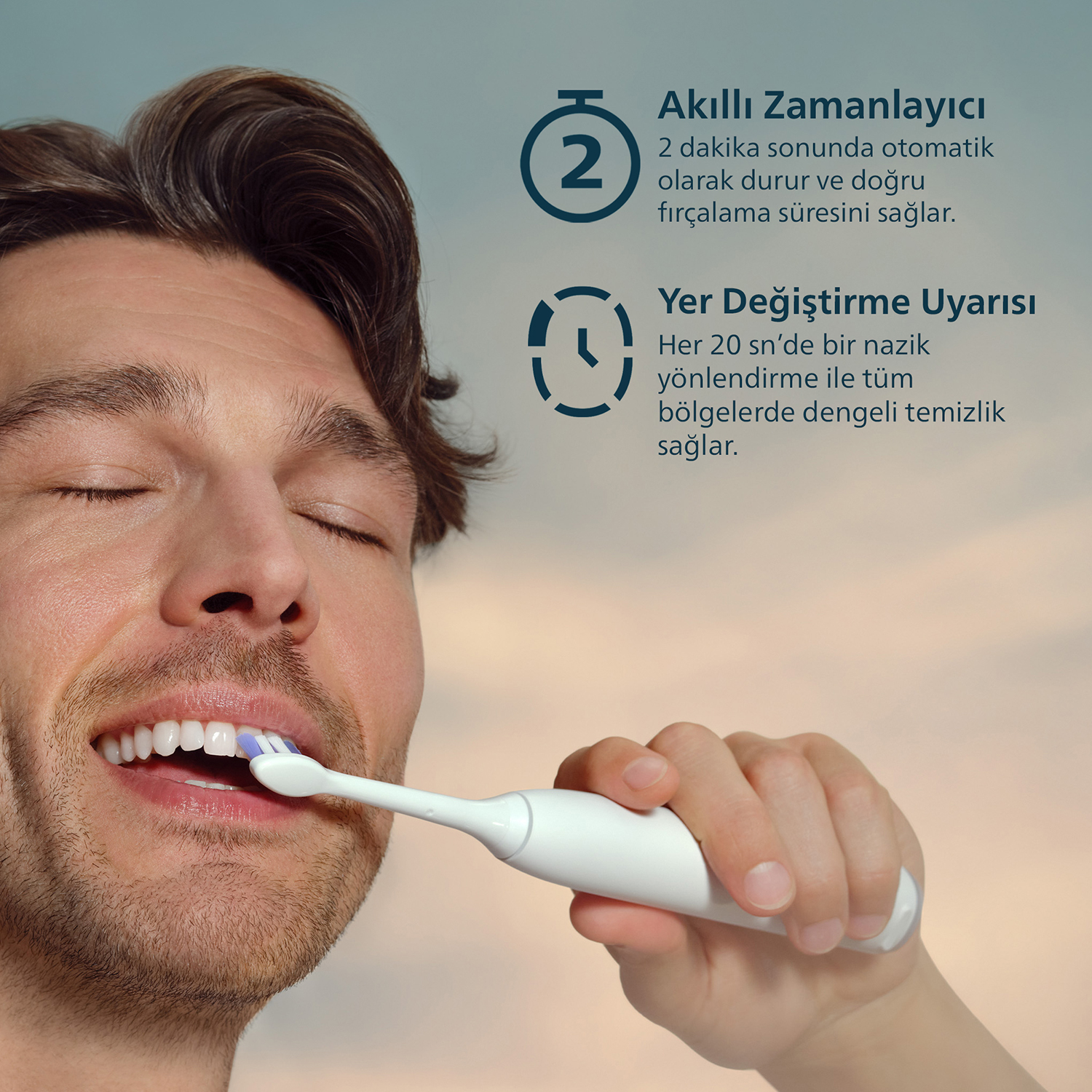 Erkek elektrikli diş fırçasıyla dişlerini fırçalıyor; zamanlayıcı fonksiyonları.