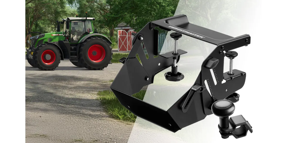 Grüner Traktor neben einem roten Schuppen und einem schwarzen Lenkradhalter.