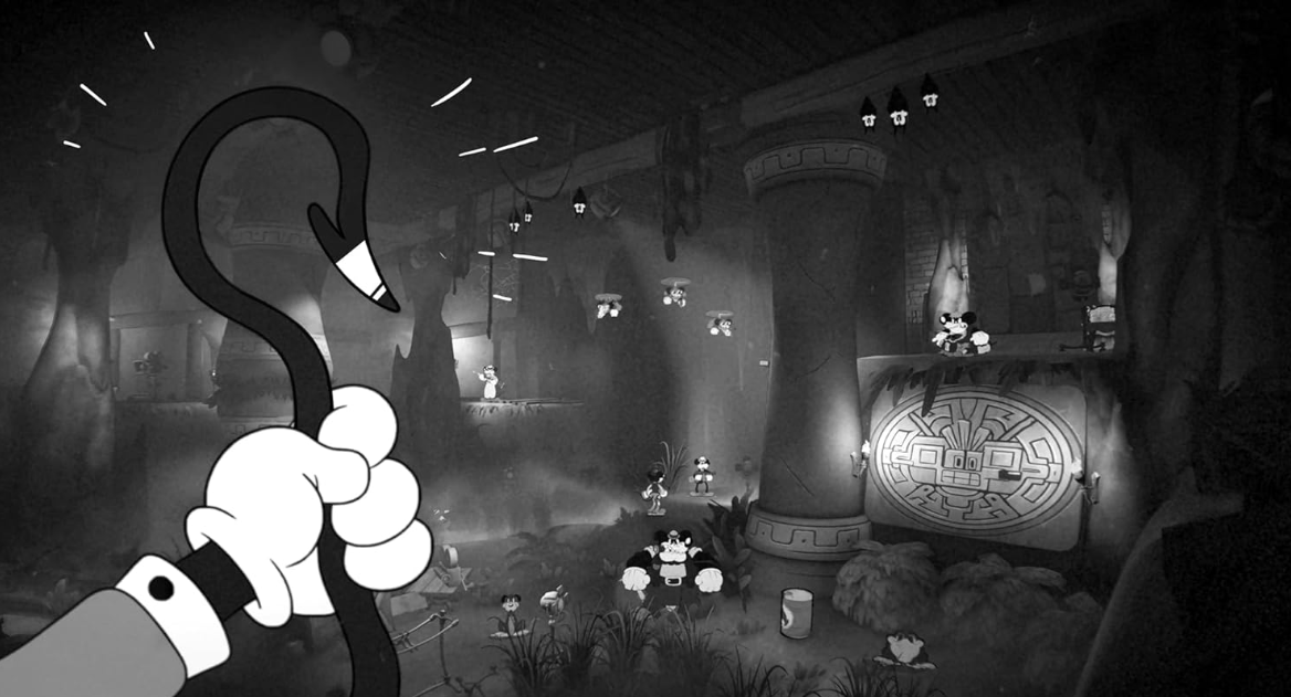 Eine Hand hält einen Haken in einer Höhle mit Micky-Maus-Figuren.