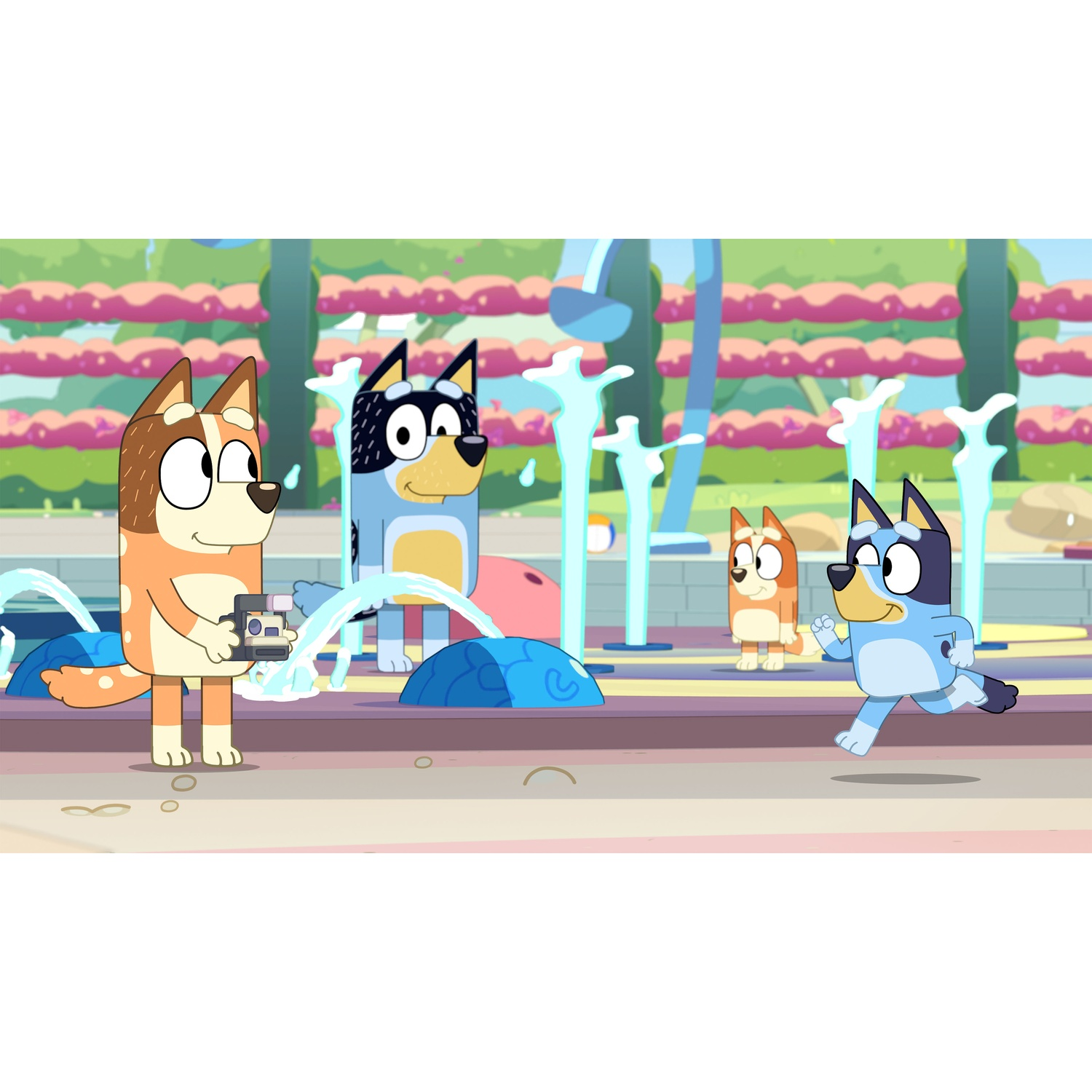 Four cartoon dogs in a park with water fountains. One holds a camera.
