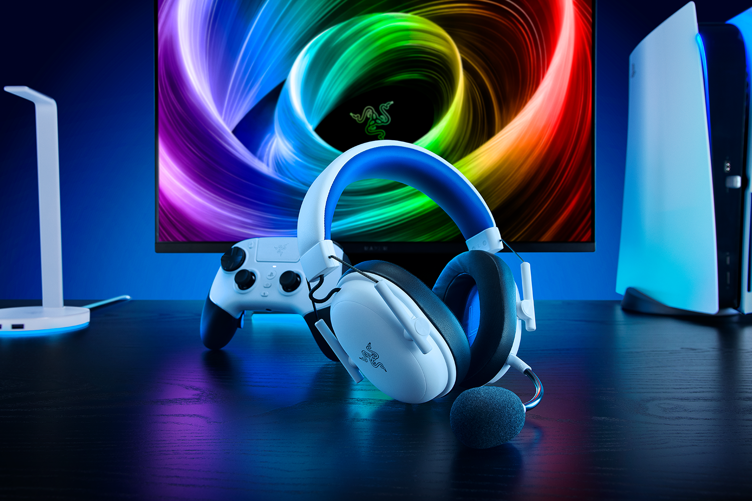 Gaming-Setup: Kopfhörer, Controller, Konsole und Monitor mit buntem Hintergrund.