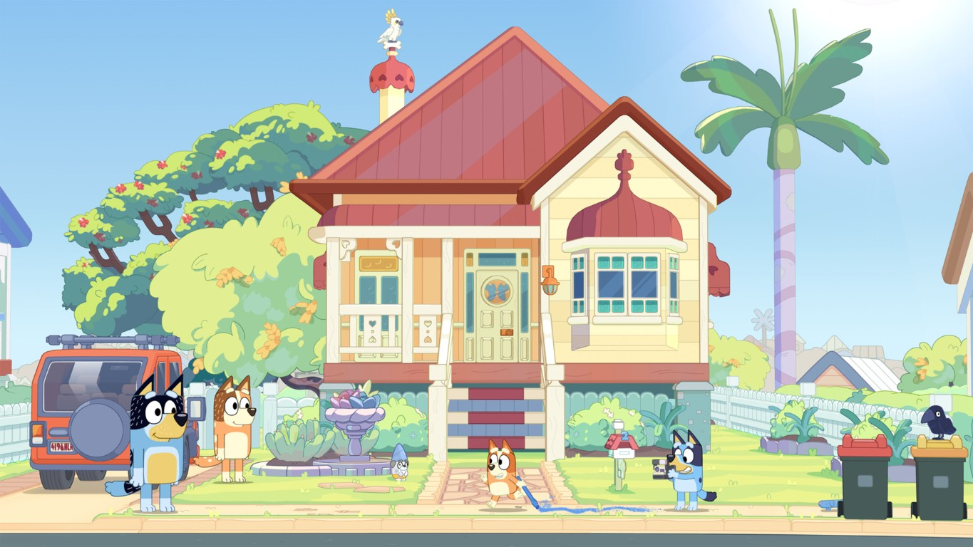 Psy bawią się przed domem z pomarańczowym samochodem i koszami na śmieci.