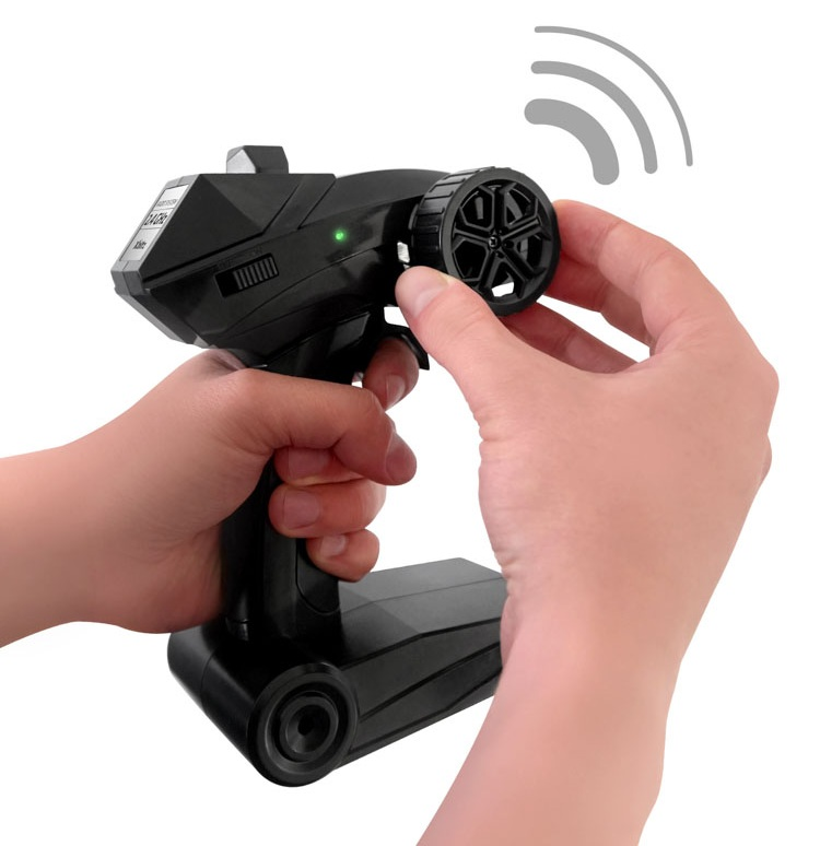 Dłonie obsługujące czarny pilot z małym kółkiem i falami sygnału.