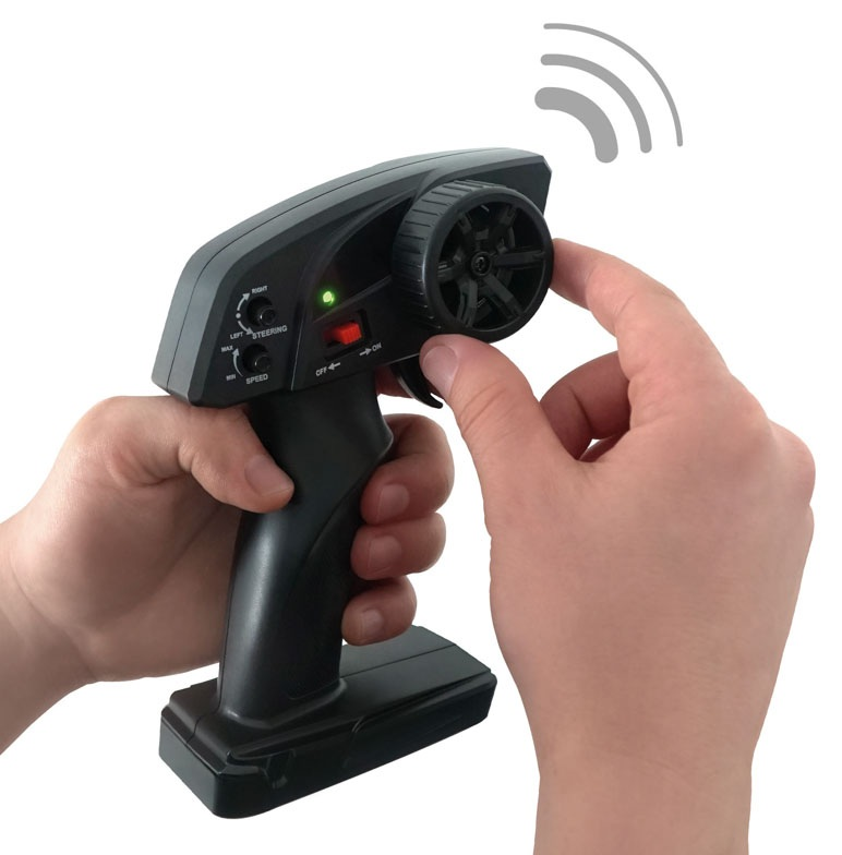 Jedna ręka trzyma czarny pilot, druga kręci kółkiem.