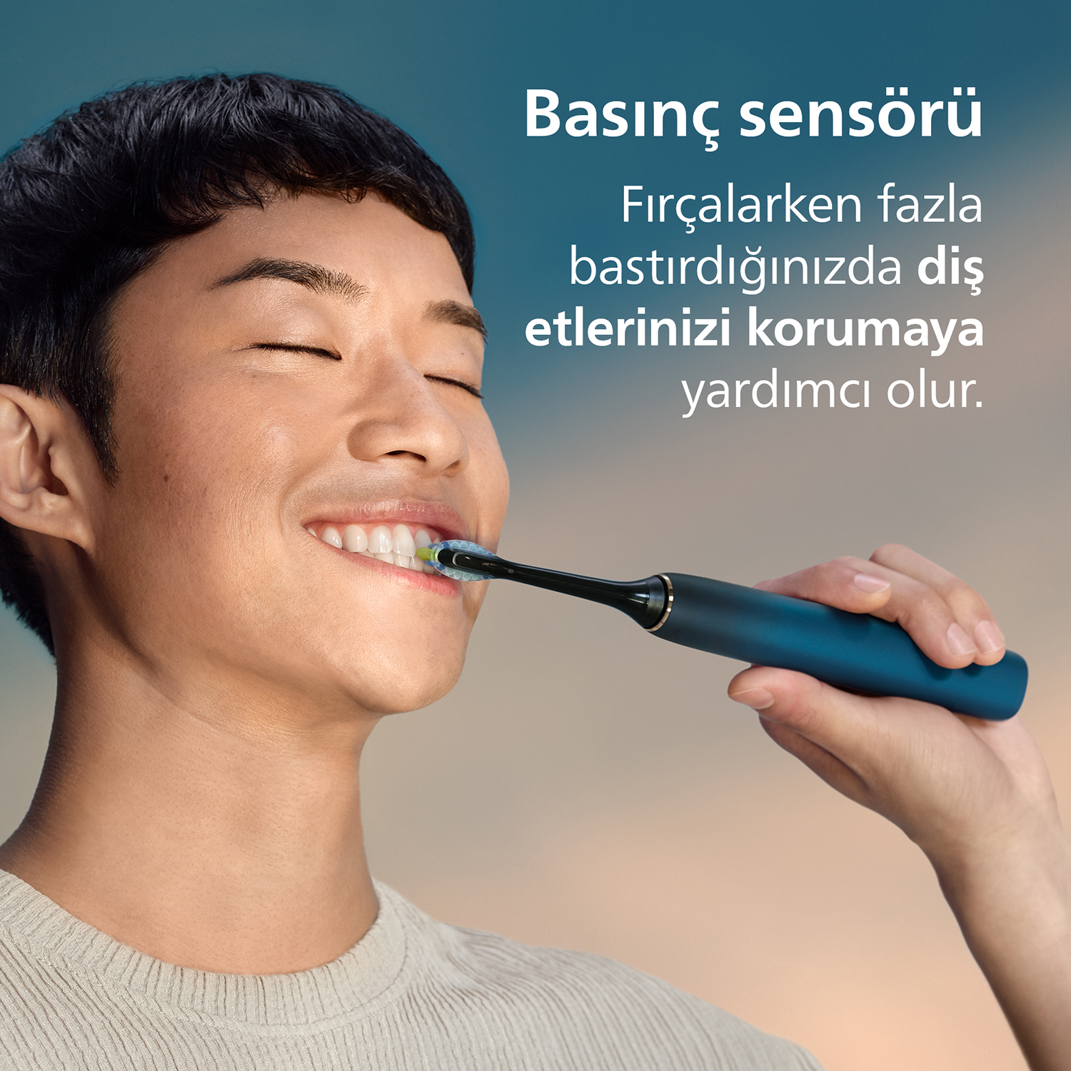 Erkek, basınç sensörlü elektrikli diş fırçasıyla dişlerini fırçalıyor.