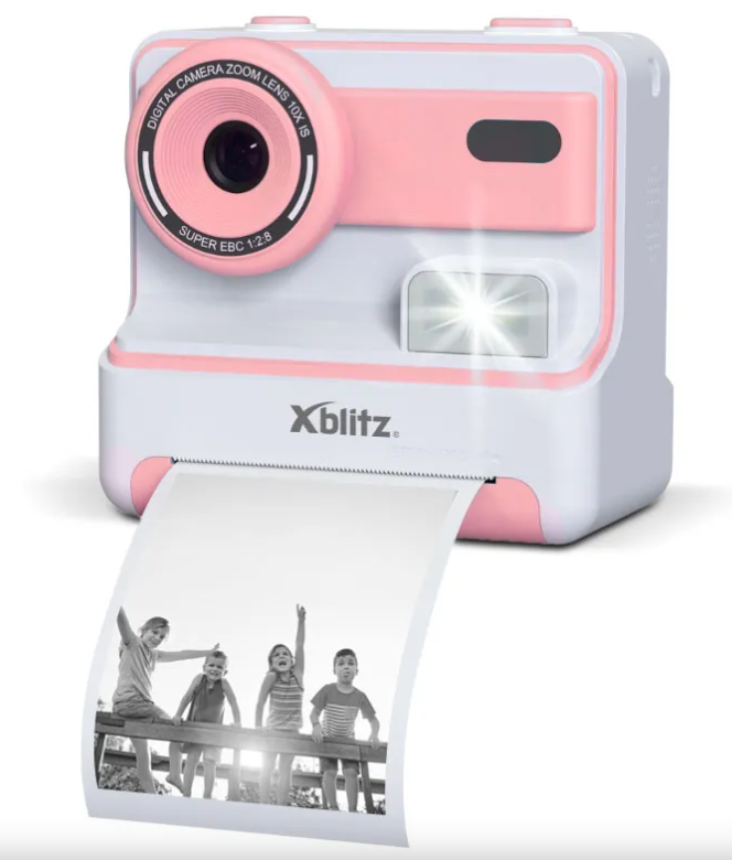 Różowo-biały aparat cyfrowy drukuje zdjęcie czworga dzieci siedzących na drewnianej balustradzie.