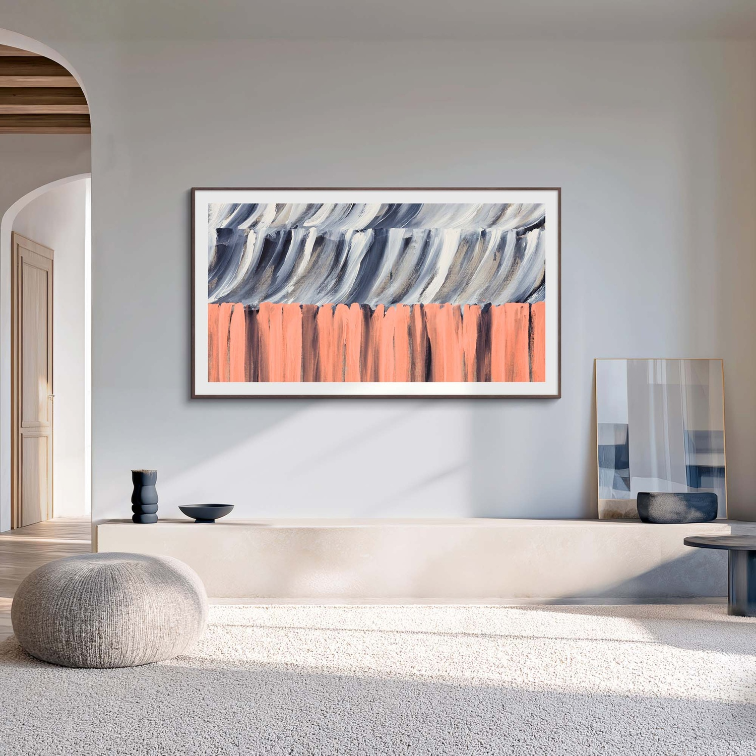 Arte astratta con pennellate corallo e grigio appesa sopra una mensola minimalista con decorazioni.