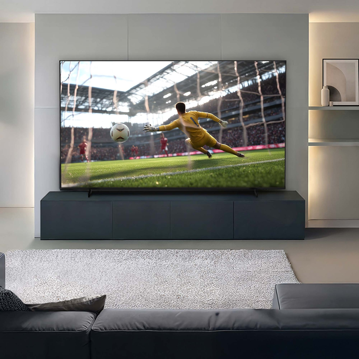 Un portiere in giallo si tuffa per un pallone da calcio. Campo erboso, stadio, divano e TV.