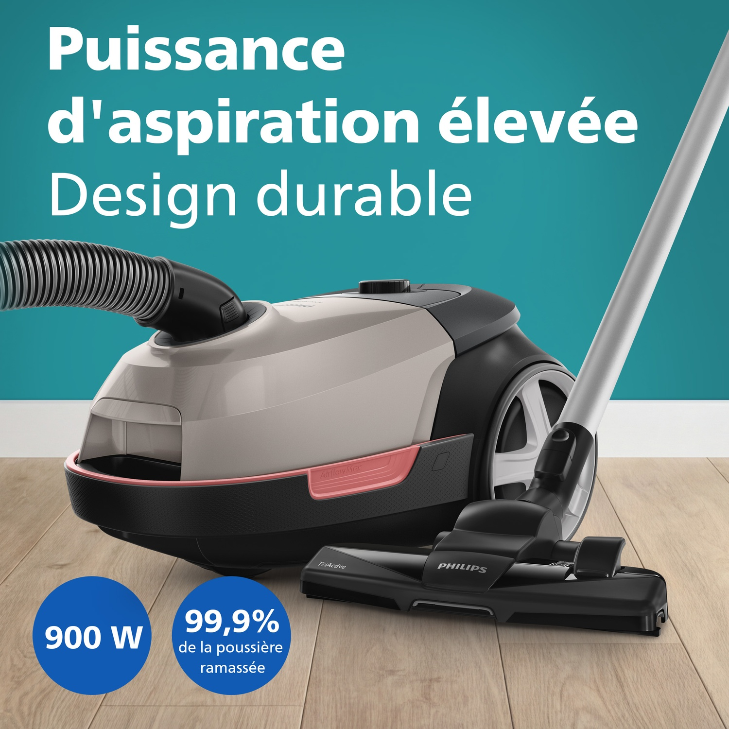 Un aspirateur Philips beige et noir avec tuyau et manche sur un plancher en bois.
