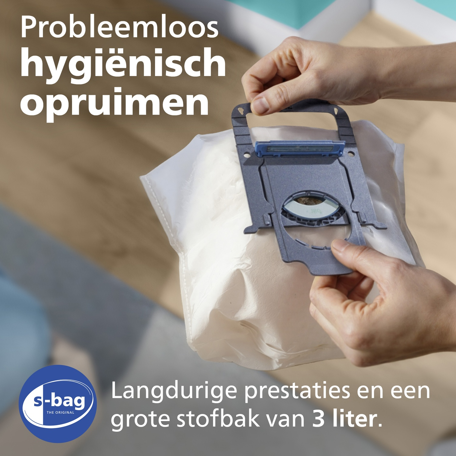 Hands hold an s-bag dust bag. Text in Dutch.