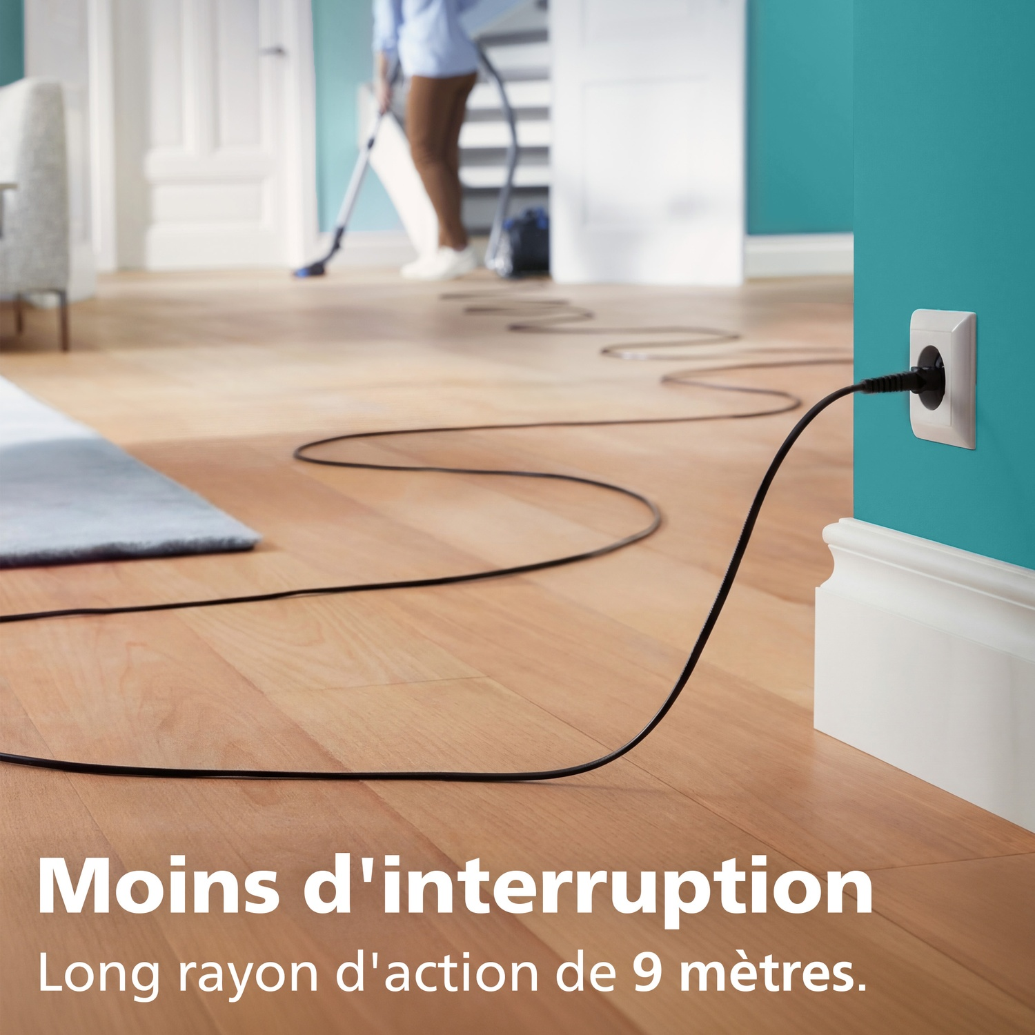 Un cordon noir relie une prise murale à un aspirateur.