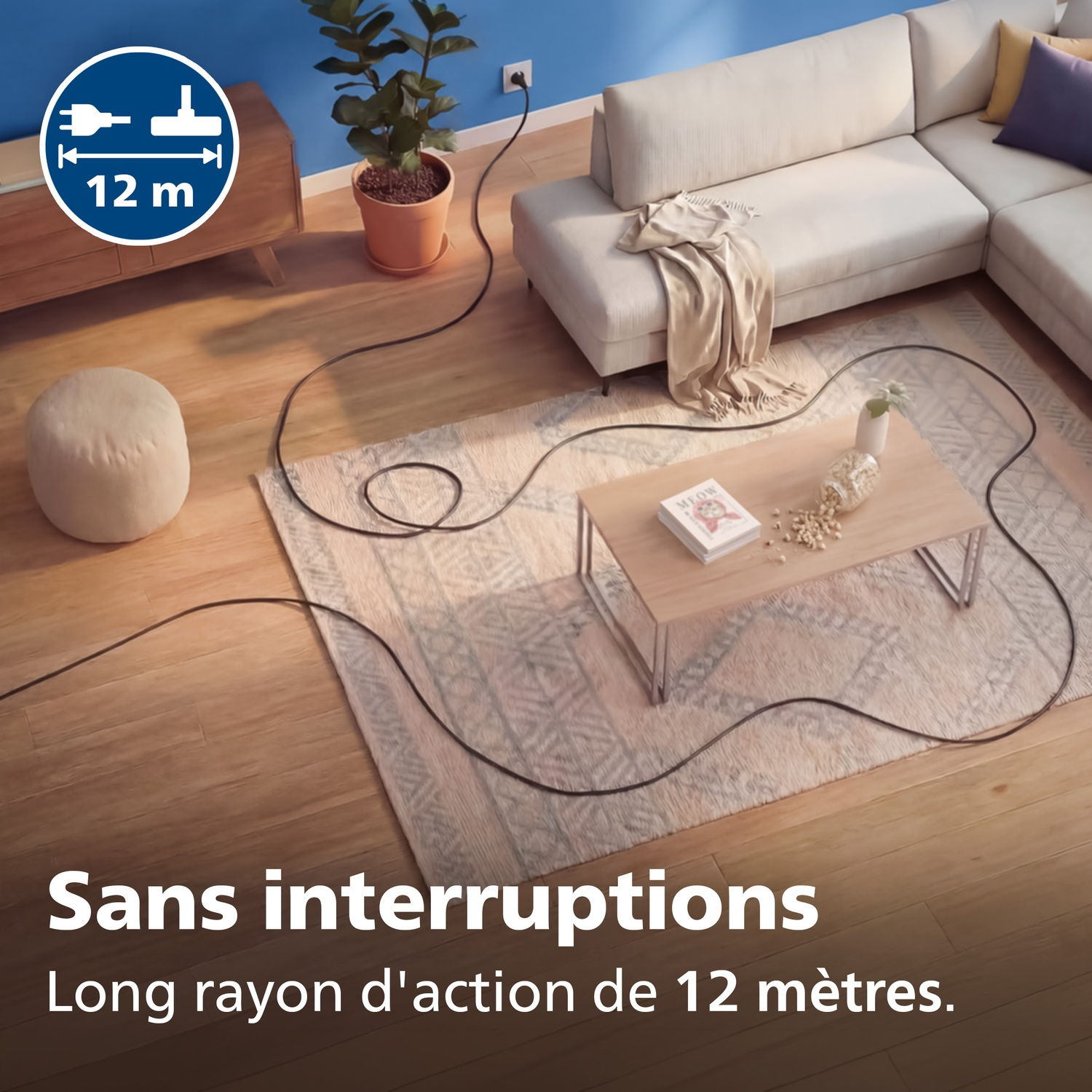 Un long cordon noir relie une prise murale à un aspirateur dans un salon.