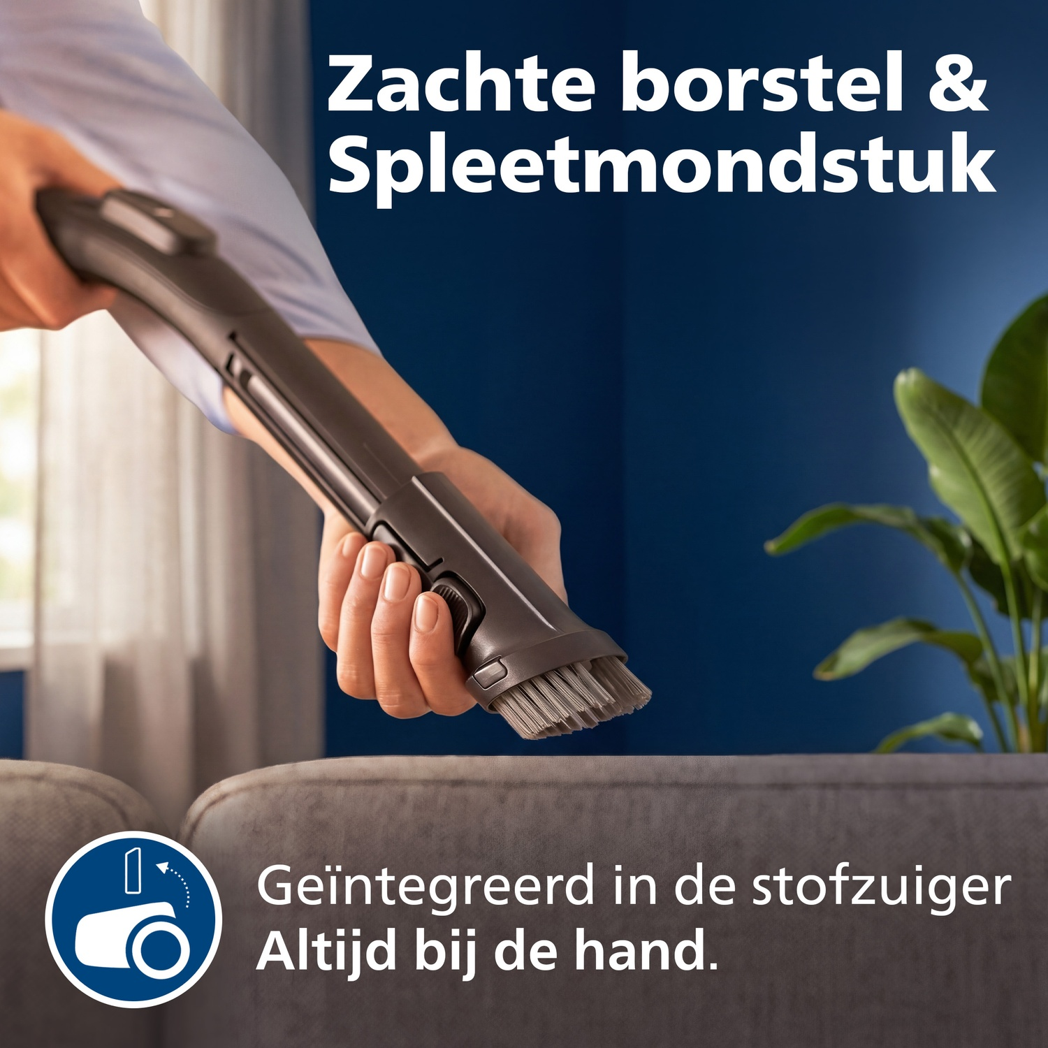 A person holds a vacuum cleaner nozzle with a brush and crevice tool.