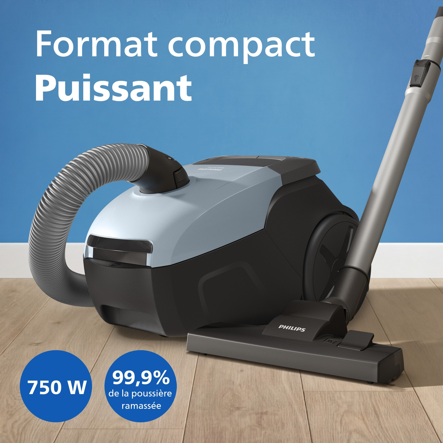 A blue Philips vacuum cleaner with hose and tube on a wooden floor.