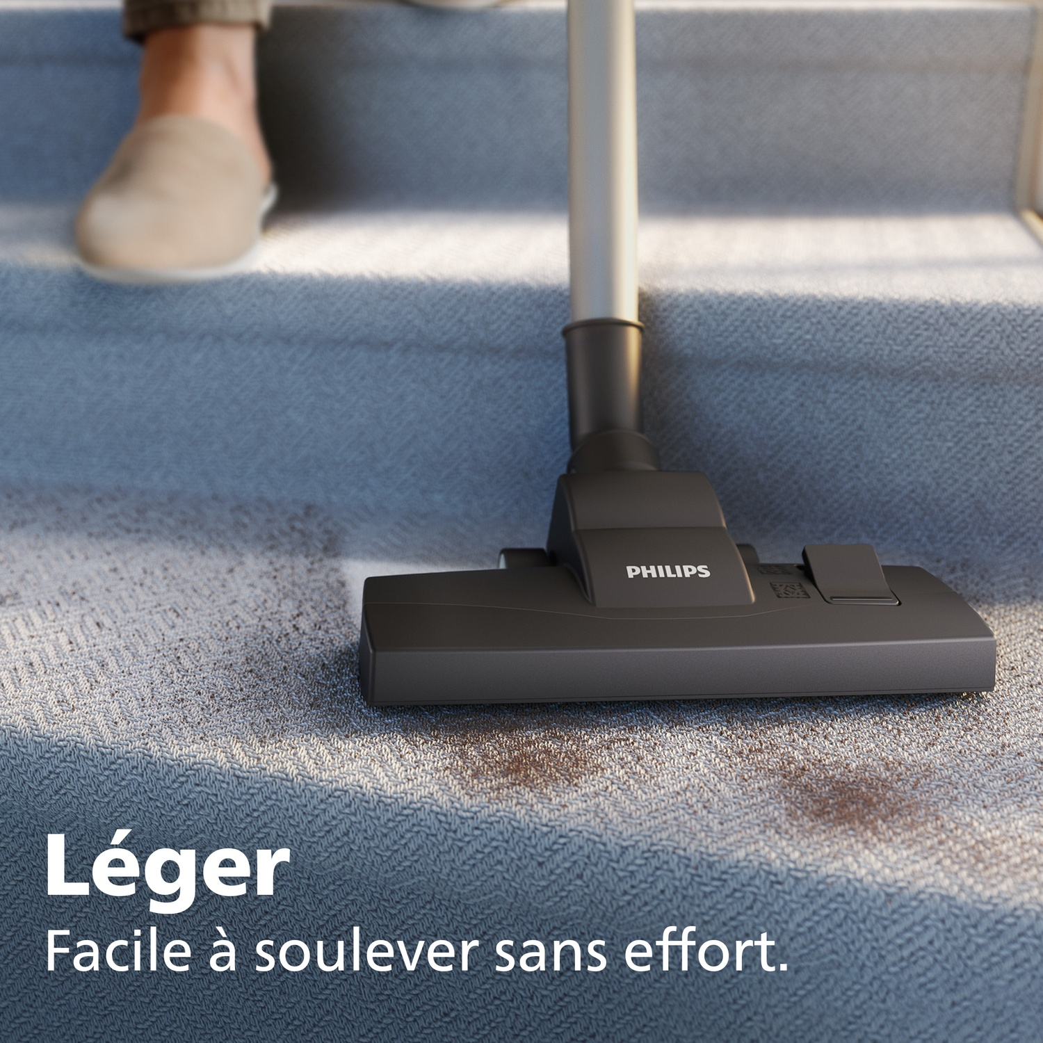 Philips vacuum nozzle cleans dirty stairs. A person in slippers is visible.