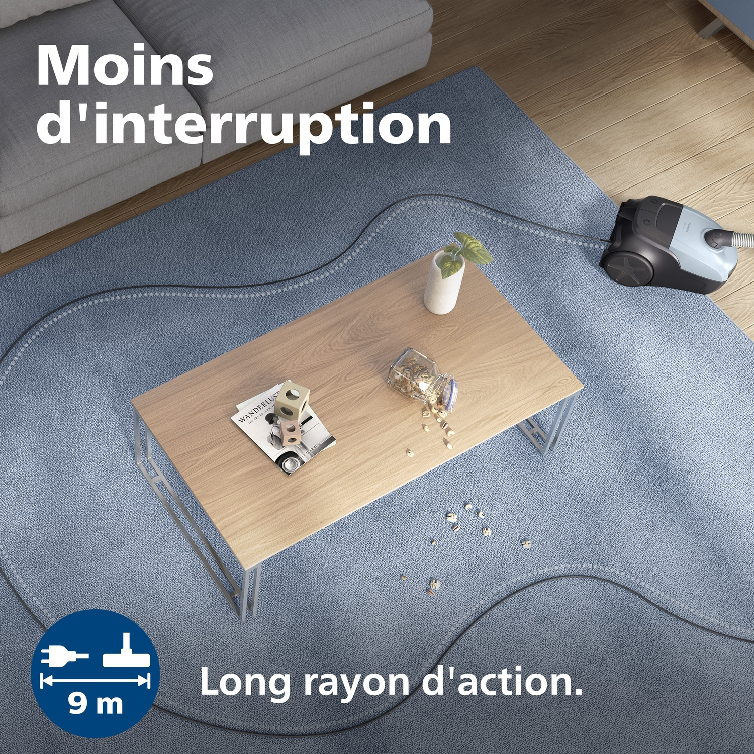 A vacuum cleaner with a long cord on a blue rug, near a coffee table.