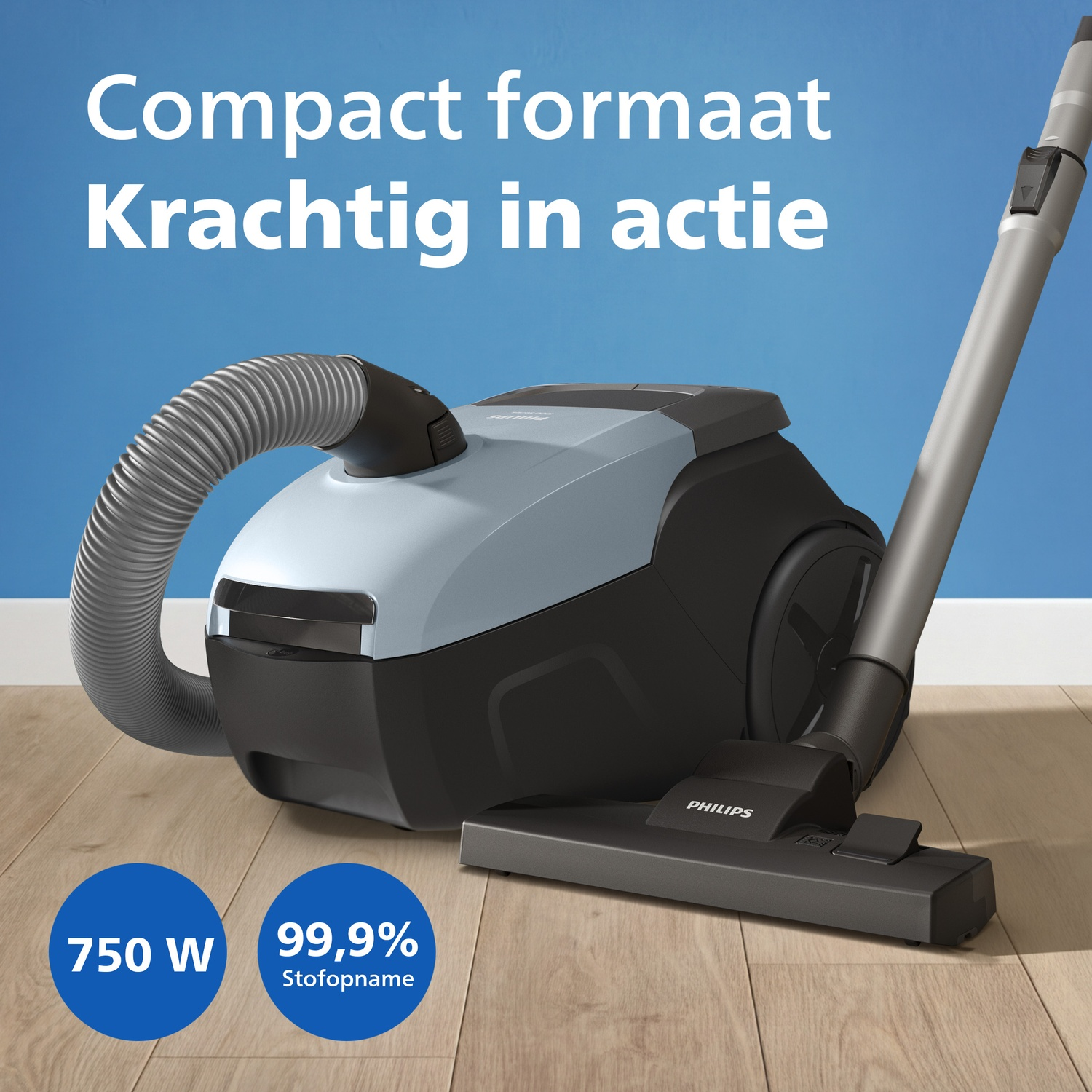 A grey Philips vacuum cleaner with hose and tube on a wooden floor.