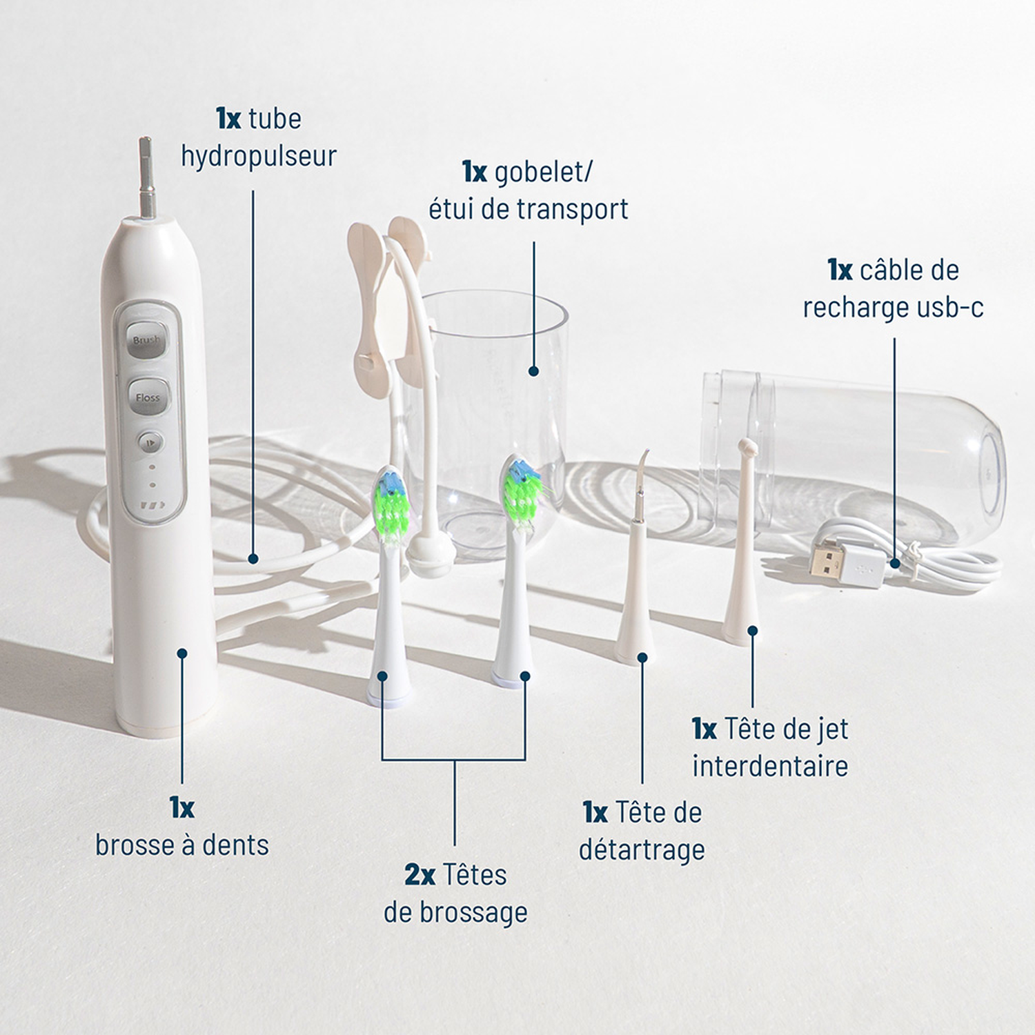 A white oral hygiene device with various attachments and charging cable on a light background.