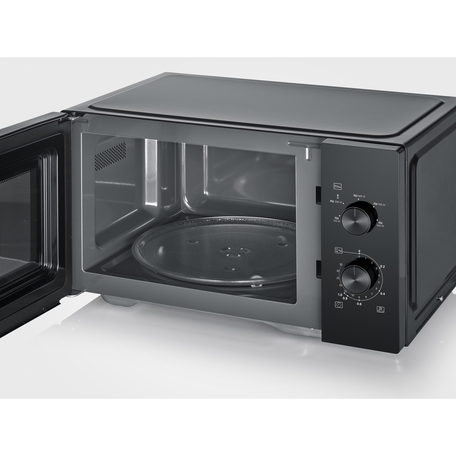 Black microwave with open door, glass turntable, and control dials.