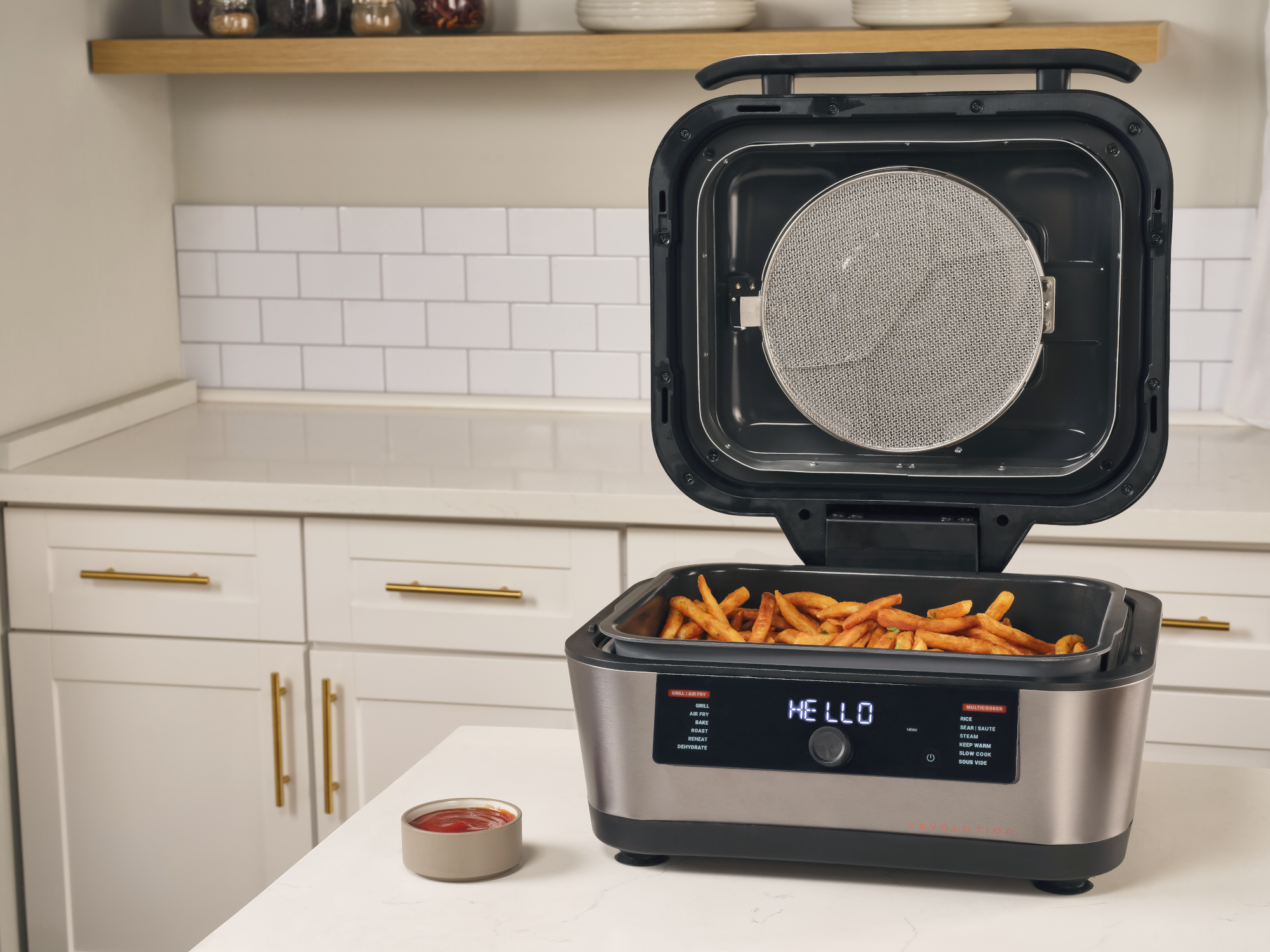 Egy nyitott légkeveréses fritőz sült krumplival és ketchupos tálkával a konyhapulton.
