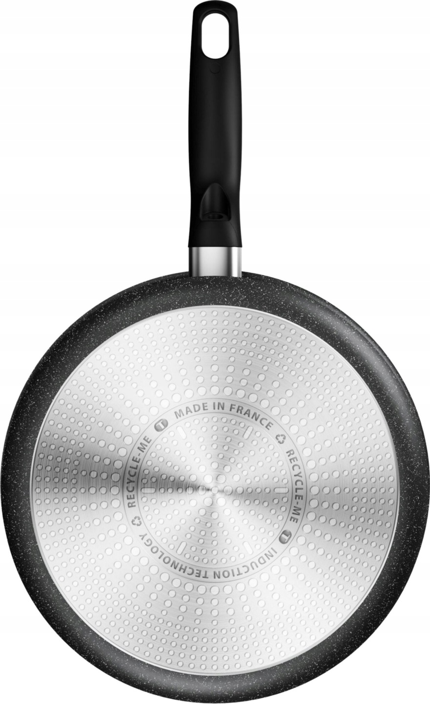 Dno patelni z czarnym uchwytem i okrągłym wzorem.