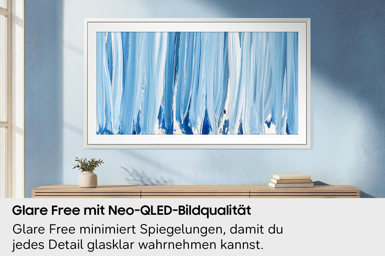 Ein weiß gerahmtes Bild mit blauen und weißen Pinselstrichen hängt an einer blauen Wand.