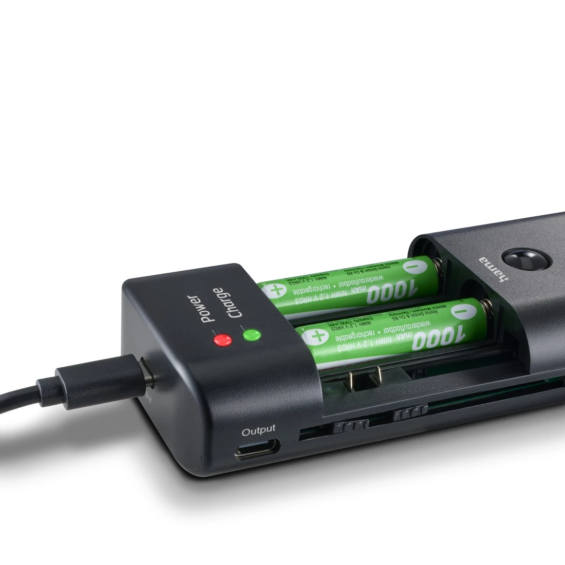 Ein schwarzes Ladegerät mit zwei AA-Batterien, eine davon leuchtet grün.