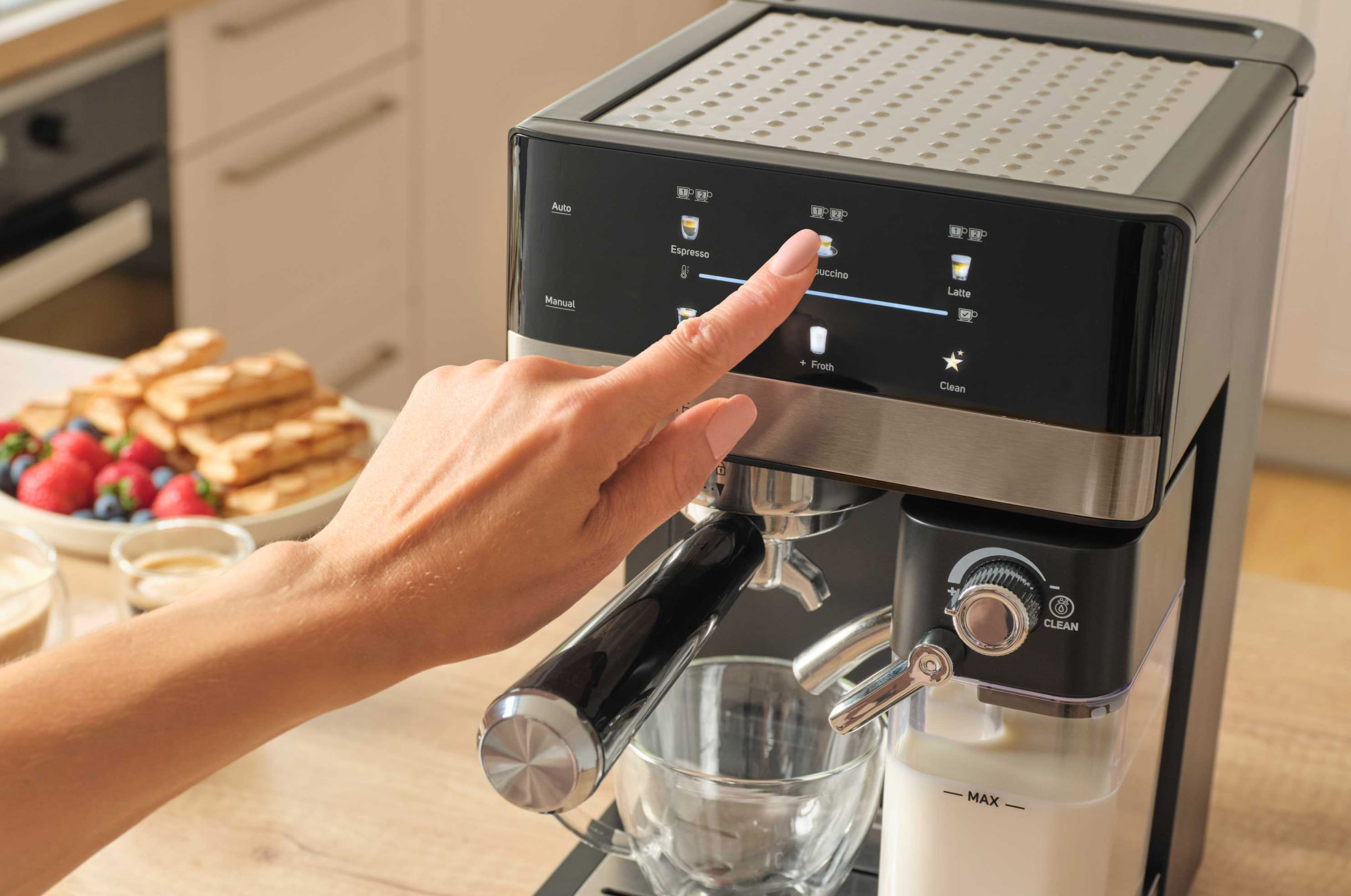 Egy kéz a cappuccino opciót nyomja meg egy kávéfőző érintőképernyőjén.