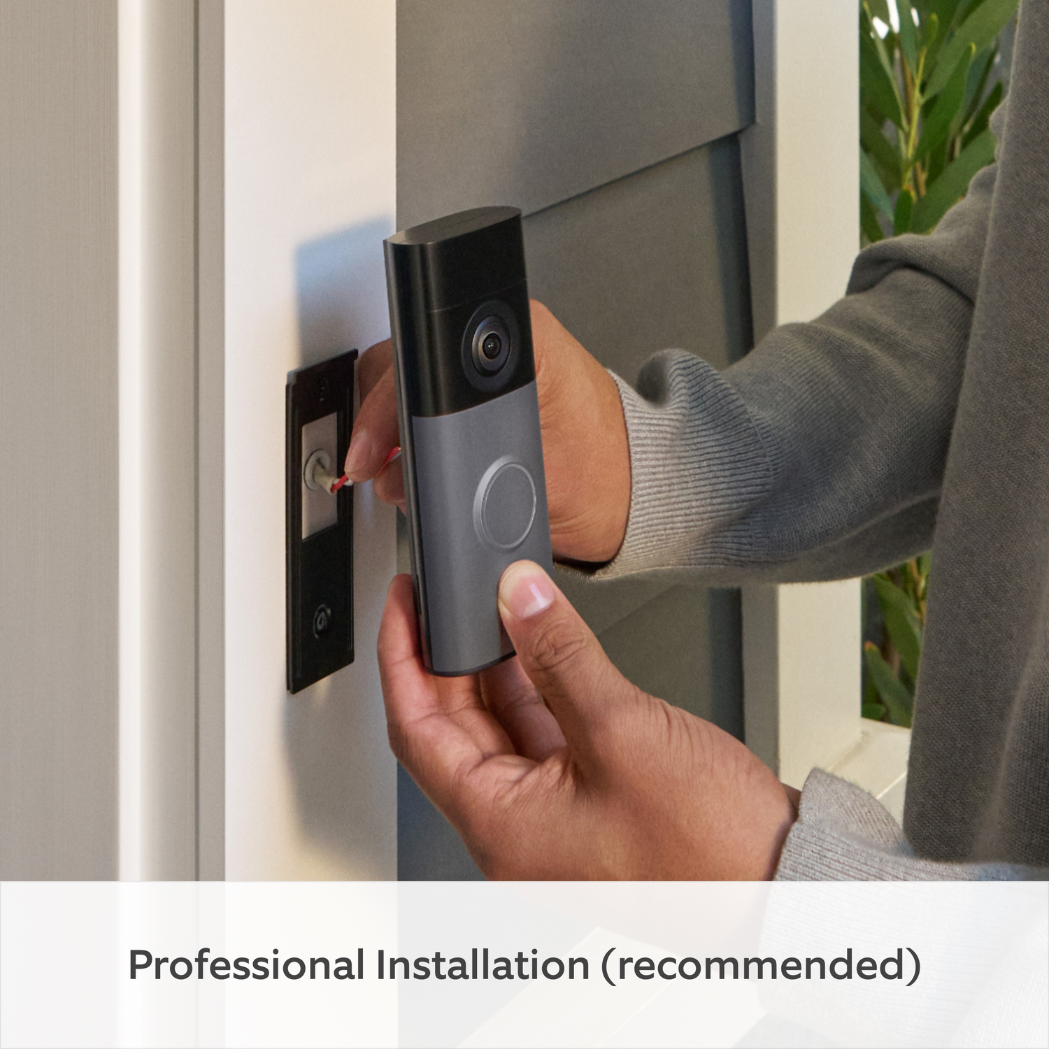Person installing a doorbell camera to a door using tools.
