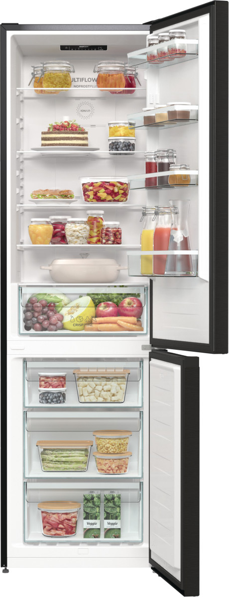 Otwarta czarna lodówka z żywnością na półkach i w szufladach.