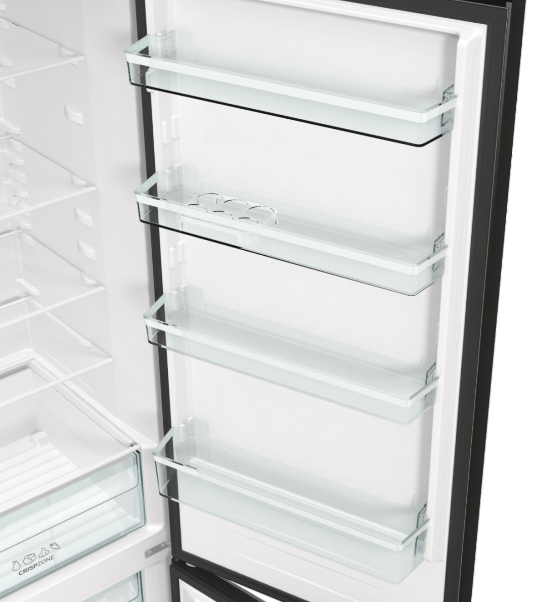 Wnętrze pustej lodówki ze szklanymi półkami i szufladami. Szuflada na warzywa na dole.